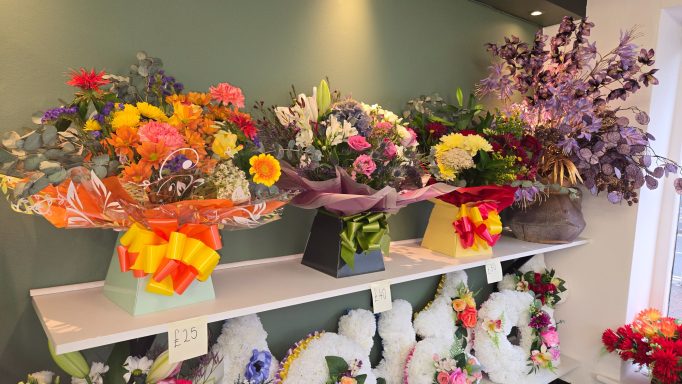 Various flower bouquets in vibrant colours displayed on a shelf.