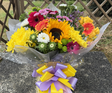 A vibrant bouquet featuring sunflowers, daisies, and various colourful flowers.